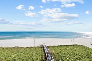 A beach with a wooden walkway leading to the shore. - La Playa 303 by Liquid Life (Pensacola)