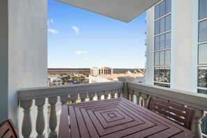Ein Balkon mit Blick auf eine Stadtlandschaft, einem Tisch und einer Bank.