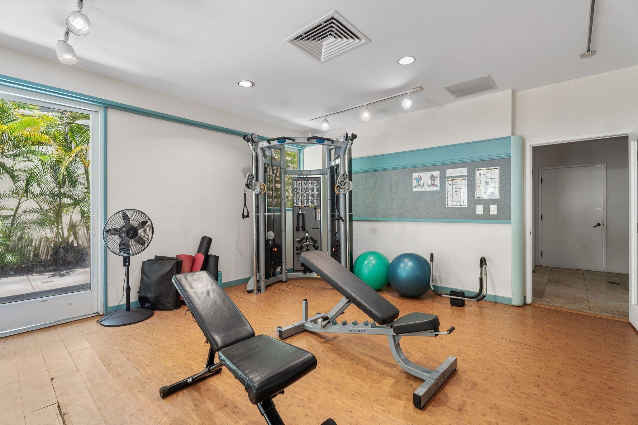 A gym with a bench press, a squat rack, and exercise balls.