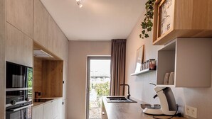 Una cucina moderna con mobili in legno, forno integrato e macchina da caffè.
