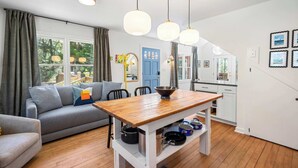 Een moderne woonkamer met een bank, eettafel en keukenhoek.