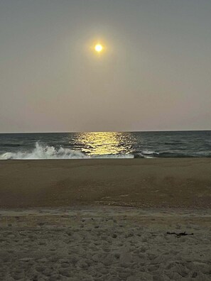 A beach with the sun reflecting on the water. - Beachwalk 20, Steps to the Beach, Outdoor Pool (Ocean City)