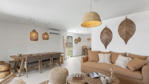 Ein modernes Wohnzimmer mit Sofa, Couchtisch und Essbereich.