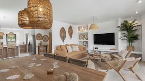 Ein modernes Wohnzimmer mit einem Holzesstisch, einer Couch und einem Fernseher.