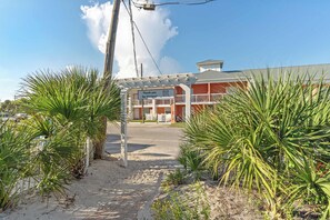 A building with a sign thanking visitors, a paved entrance, and surrounding palm trees. - Tropical Isle 209🌴Beach Access👙 (Fort Walton Beach)