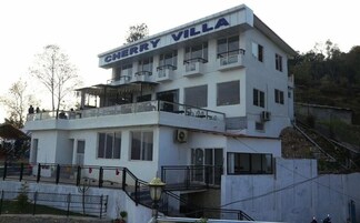 A multi-story building named Cherry Villa with balconies, large windows, and a staircase leading to the upper level.