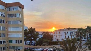 Un quartier résidentiel avec une piscine, des voitures garées et des immeubles d’appartements.