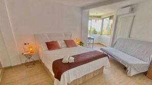 Une chambre moderne avec un grand lit, un canapé et une petite table avec une lampe.