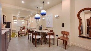 A modern dining area with a round table, wooden chairs, and pendant lighting. - Marais Rue Archives next to Picasso Museum, Place des Vosges,and Rue de Bretagne (Paris)