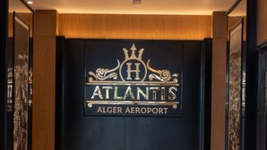A luxurious lobby with a large sign reading "ATLANTIS ALGER AEROPORT" above a plush sofa. - Atlantis Alger Aéroport ex Ibis (Algiers)