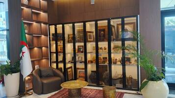 Un hall con zona de estar, exhibición de objetos decorativos e insignia.