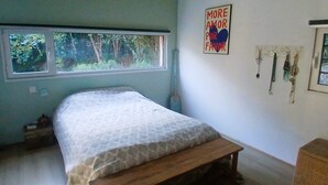 A bedroom with a bed, a window, a wall-mounted light fixture, and a framed picture. - Atypical house in a green setting only 20 minutes from Nice (Contes)