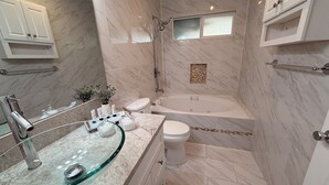 A modern bathroom with a glass sink, a bathtub, and a shower.