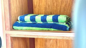 A wooden shelf with folded towels.