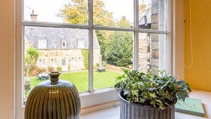 A window with a view of a stone building and a garden. - Glyn y Weddw - sleeps 8 guests  in 4 bedrooms (Llanbedrog)
