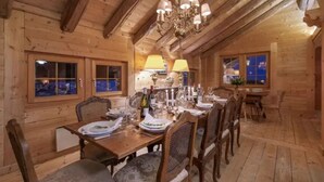A wooden dining room with a chandelier, wooden walls, and a table set for a meal. - CHALET NEIGE - Six Bedroom Chalet, Sleeps 12 (Verbier)
