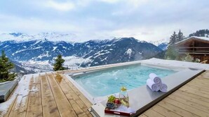 A wooden deck with a hot tub overlooking a snowy mountain range. - CHALET NEIGE - Six Bedroom Chalet, Sleeps 12 (Verbier)