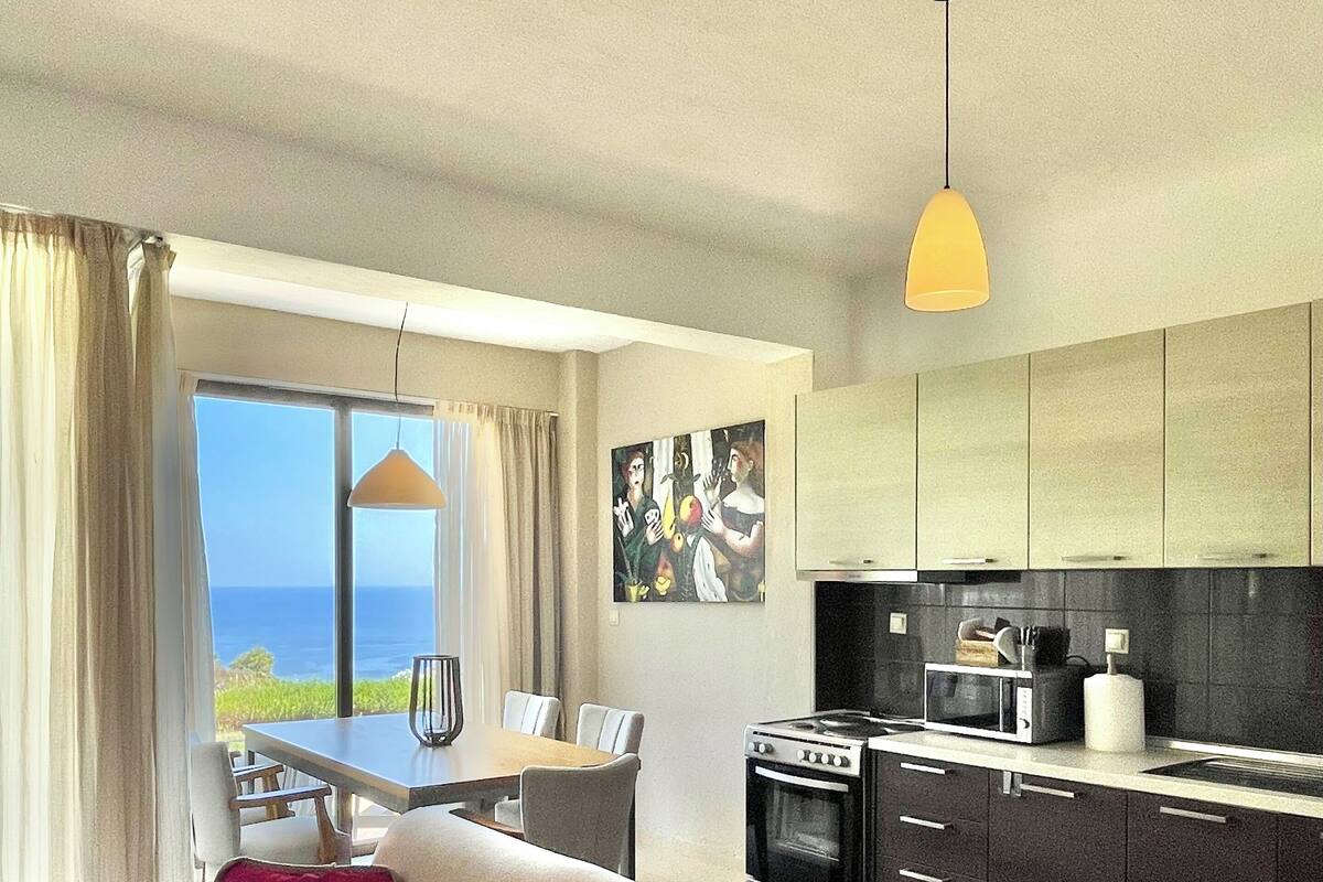 Un salon moderne comprenant un canapé, une table à manger et un coin cuisine.
