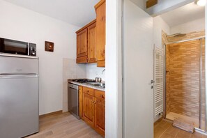 Une cuisine équipée d’un réfrigérateur, d’une cuisinière et de meubles de rangement en bois.