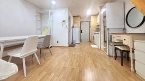 A modern apartment with a dining area, kitchenette, and a small bathroom. - JS House (Seoul)