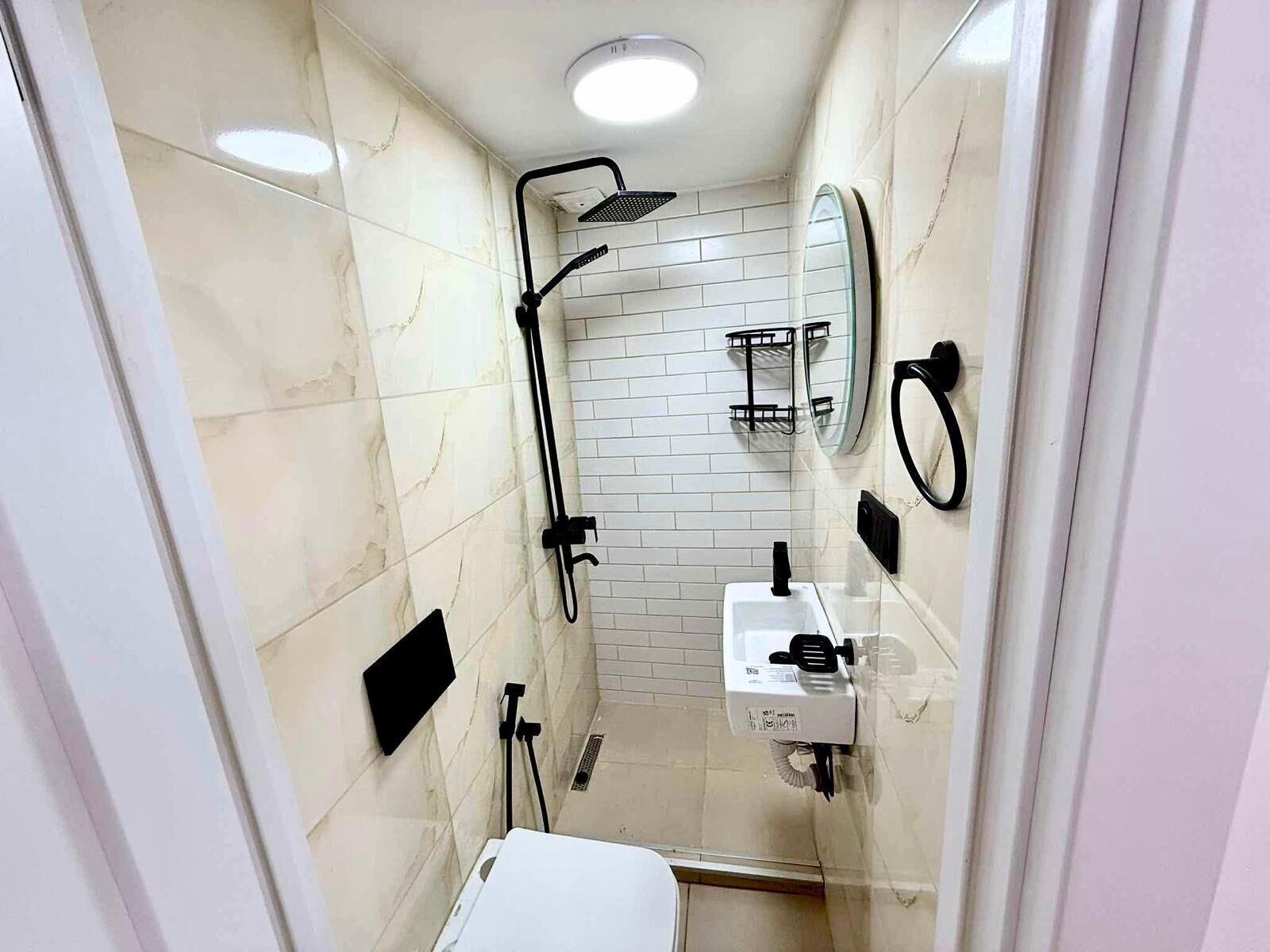 Un bagno con doccia vetrata, un lavandino bianco e uno specchio.