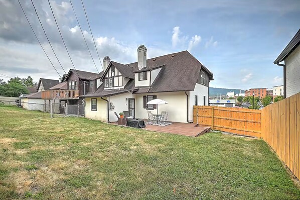 A residential property with a fenced backyard, a patio with outdoor furniture, and a chimney.