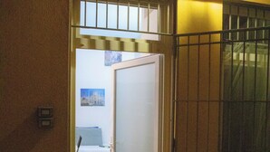 A doorway leading to a room with a bed and a chair. - Da Colomba city center (Bergamo)