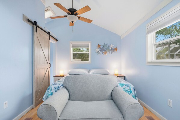 A bedroom with a bed, a ceiling fan, a window, and a door. - 2 Step: Pool, Hot Tub and Dog-Friendly (Oak Island)