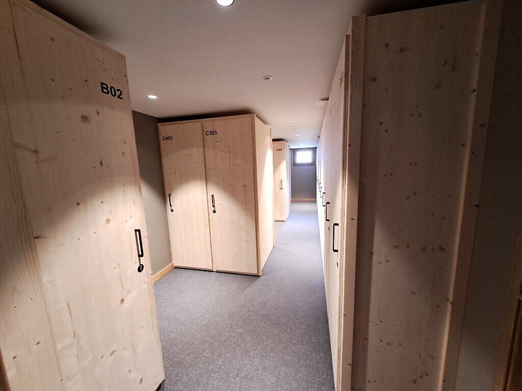 A hallway with wooden lockers labeled B02, C401, and C303.
