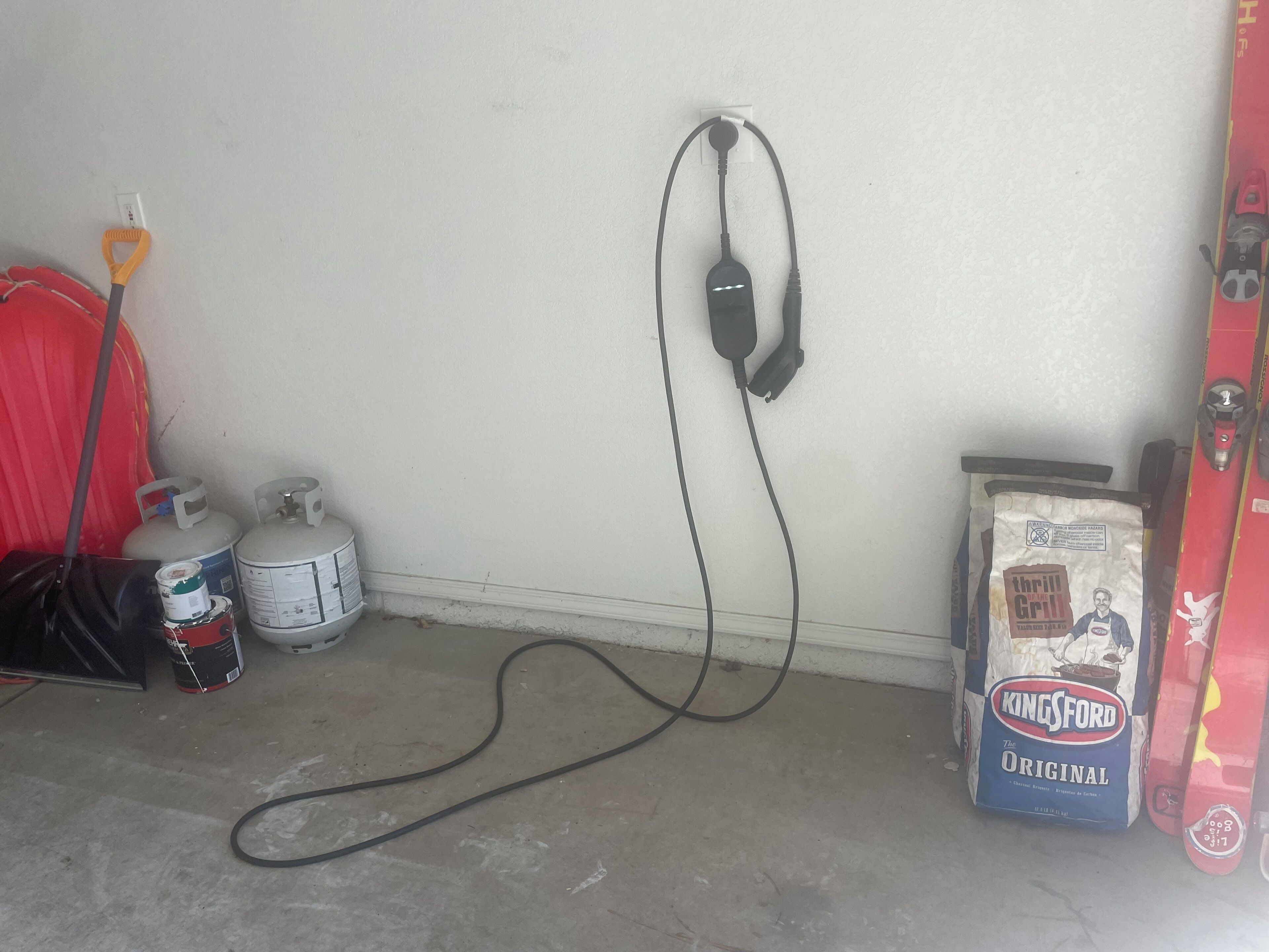 A utility room with gas cylinders, a fire extinguisher, and a bag of Kingsford charcoal.