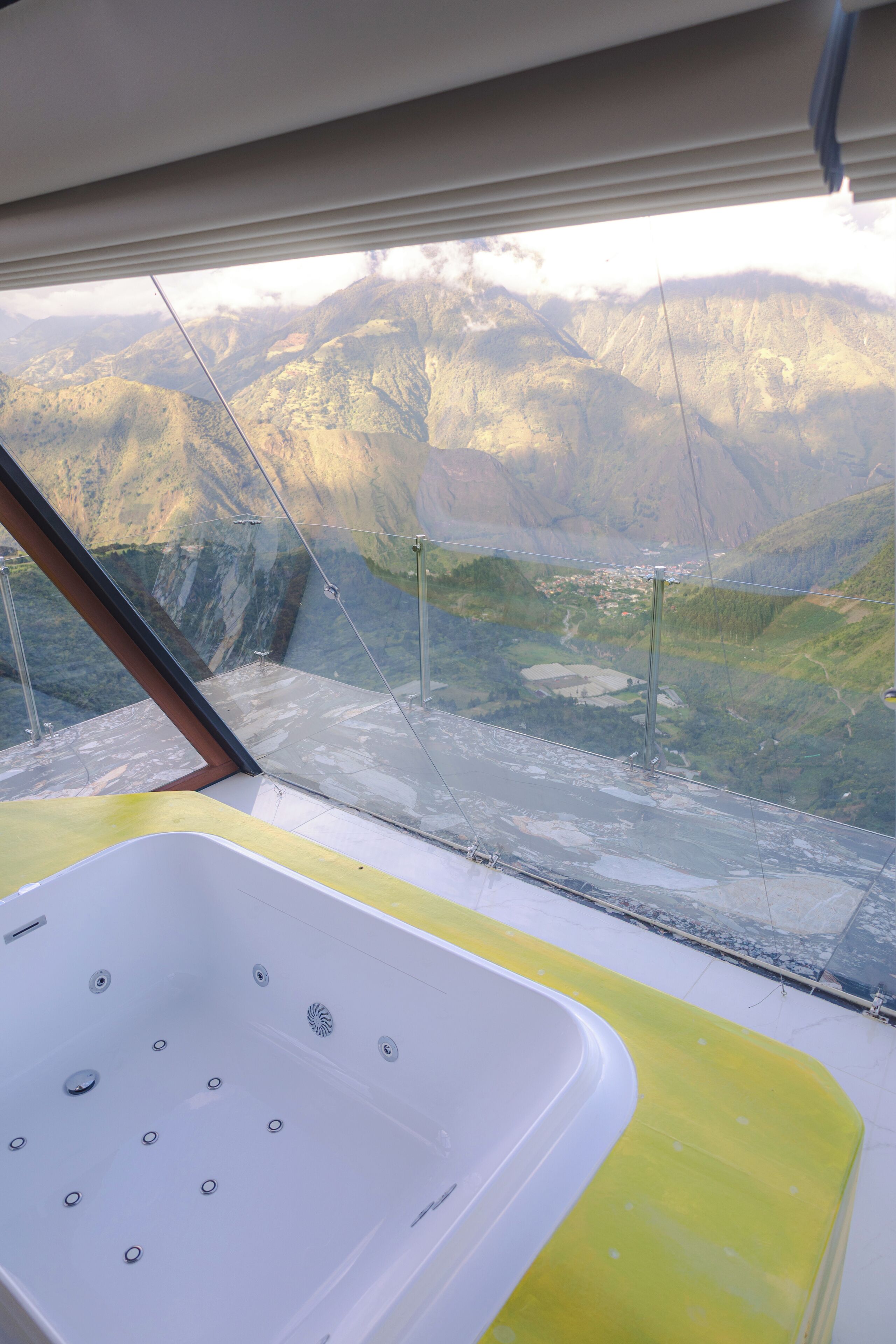 Ein modernes Badezimmer mit einer großen Badewanne und Bergblick durch ein großes Fenster.