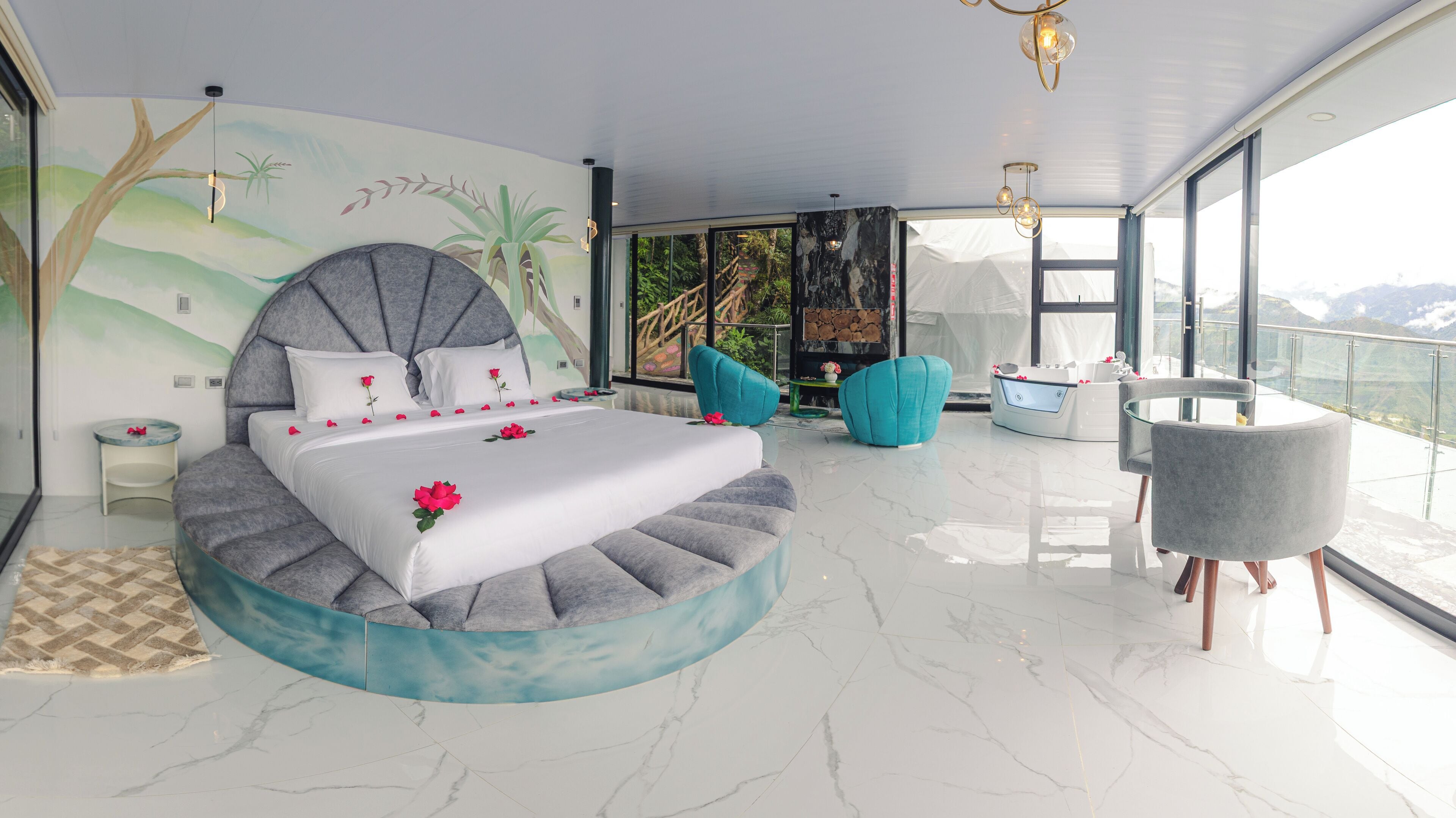 A modern bedroom with a large bed, a balcony with a view, and a seating area.