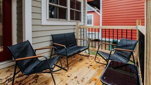 A wooden deck with three black metal chairs and a wooden table. - Oasis on 5th: walk to downtown Cville & UVA (Charlottesville,)