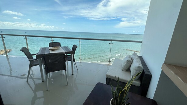 A balcony with a table and chairs overlooking the sea. - Alta Mar - Bella Cartagena Apartments (Cartagena)