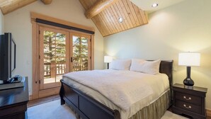 A bedroom with a large bed, wooden ceiling, and a sliding glass door leading to a balcony. - Beautiful 3 BDR Telluride Escape Close to Skiing with Private Hot Tub (Mountain Village)