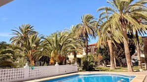 A swimming pool with a clear blue water, surrounded by palm trees and a white fence. - Finca for events (family reunions, birthdays, weddings, seminars...) (Elda)
