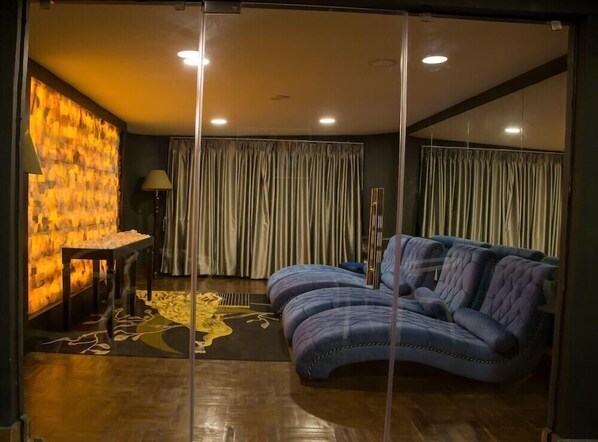Una camera da letto moderna con un divano curvo, una parete divisoria in vetro e una decorazione a parete.