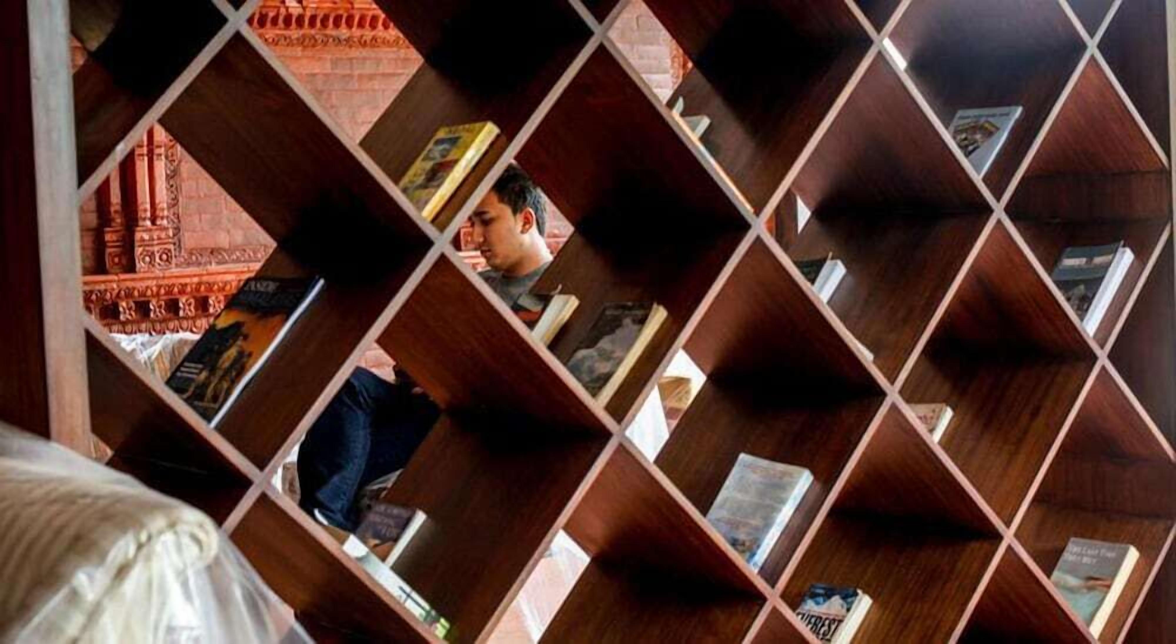 Una habitación con una original estantería geométrica llena de libros.