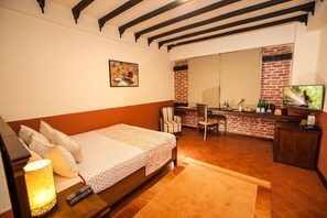A bedroom with a bed, a desk, and a TV. - Traditional Comfort (Kathmandu)