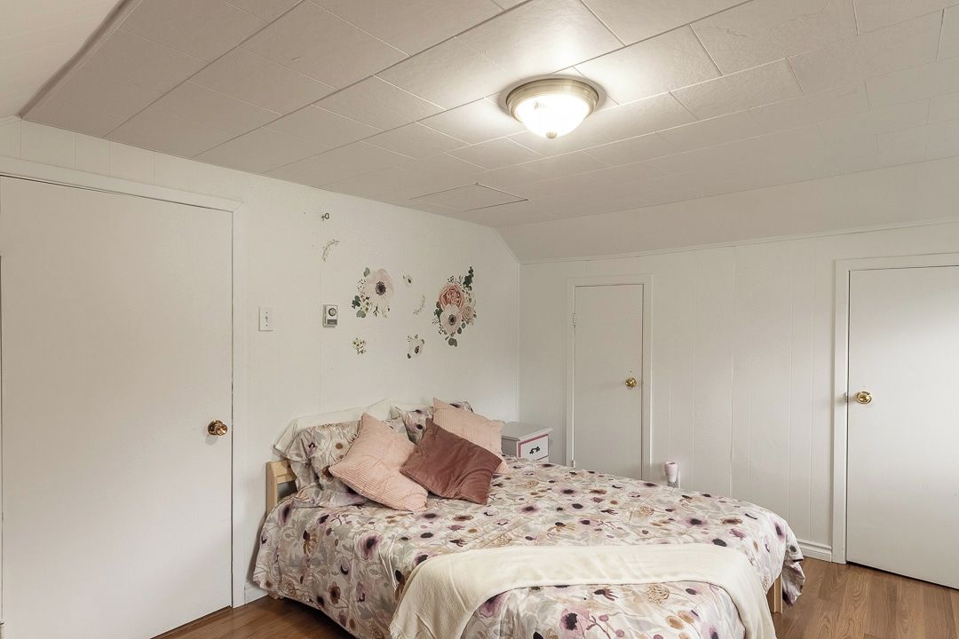 Ein Schlafzimmer mit einem Bett, einem Nachttisch und einer Wandleuchte.