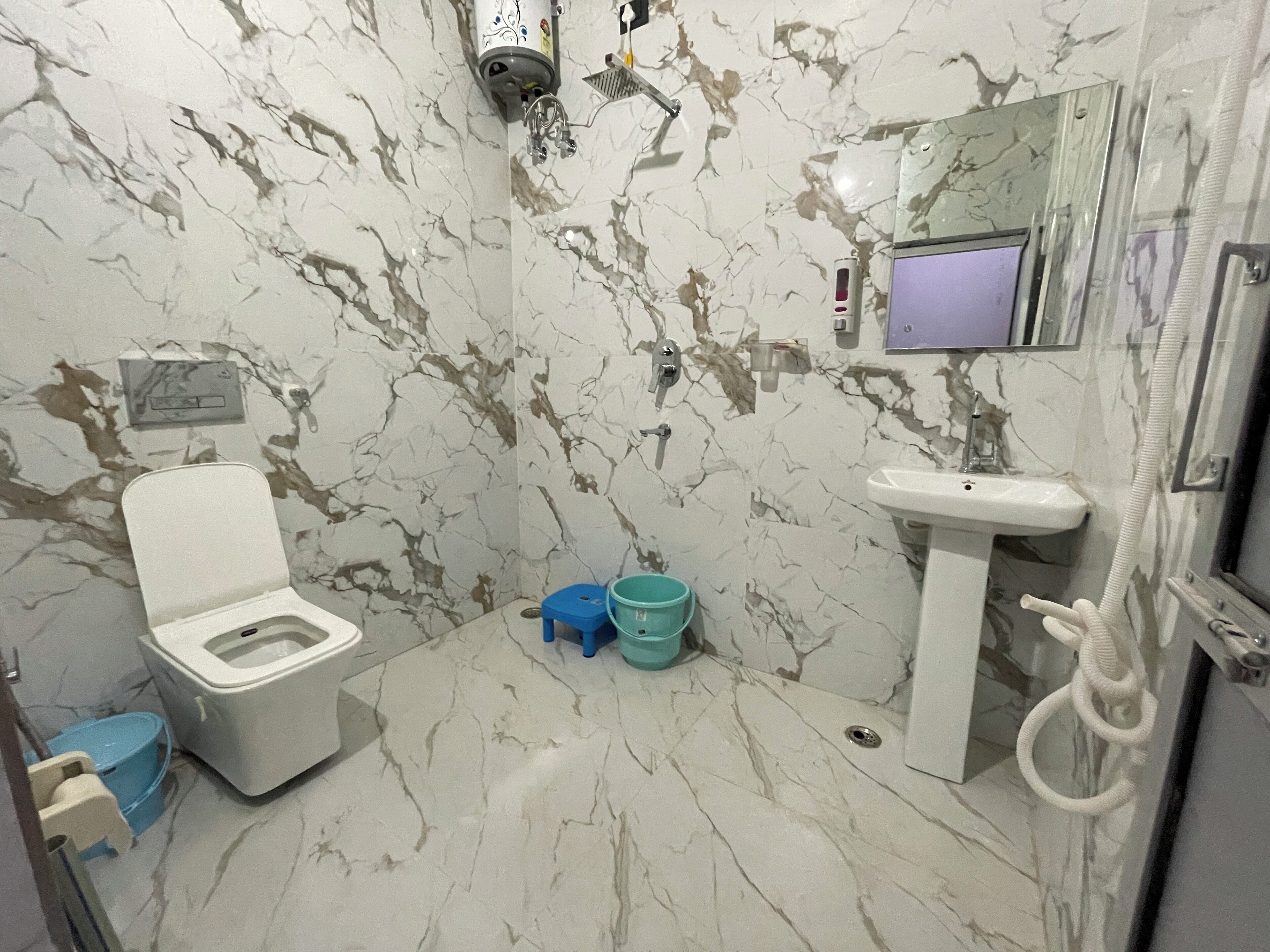 Un baño con inodoro, lavabo y ducha.