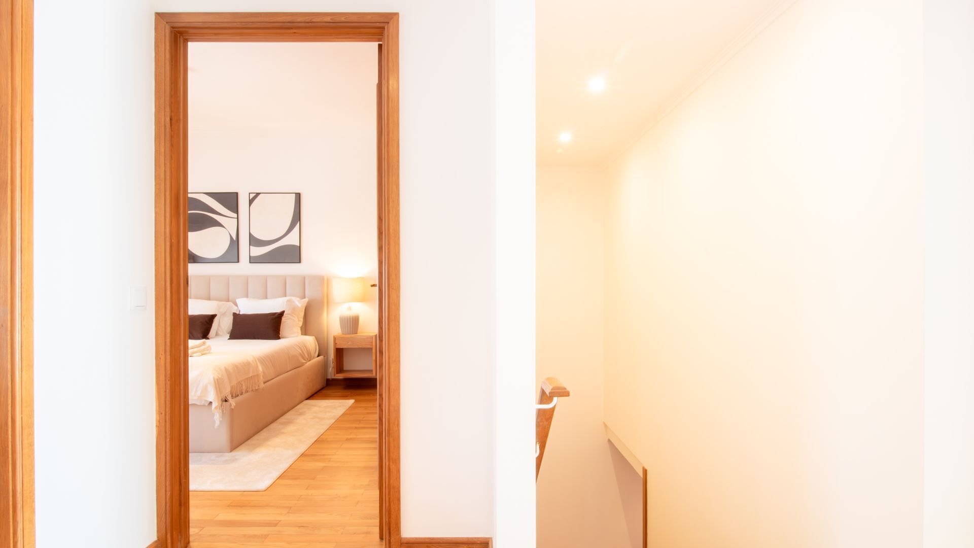 Quarto com cama, mesa de cabeceira e decoração na parede.