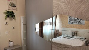 A bedroom with a mirrored wardrobe, a bed with a headboard, a bedside table, and a nightstand. - Girasole Marino - Beautiful apartment near the sea and the center of Palermo (Palermo)