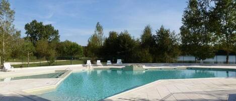 Una piscina al aire libre, una piscina climatizada