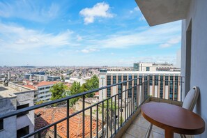 A balcony with a view of a cityscape, a table, and a chair. - Taksim Stare Hotel (Istanbul)
