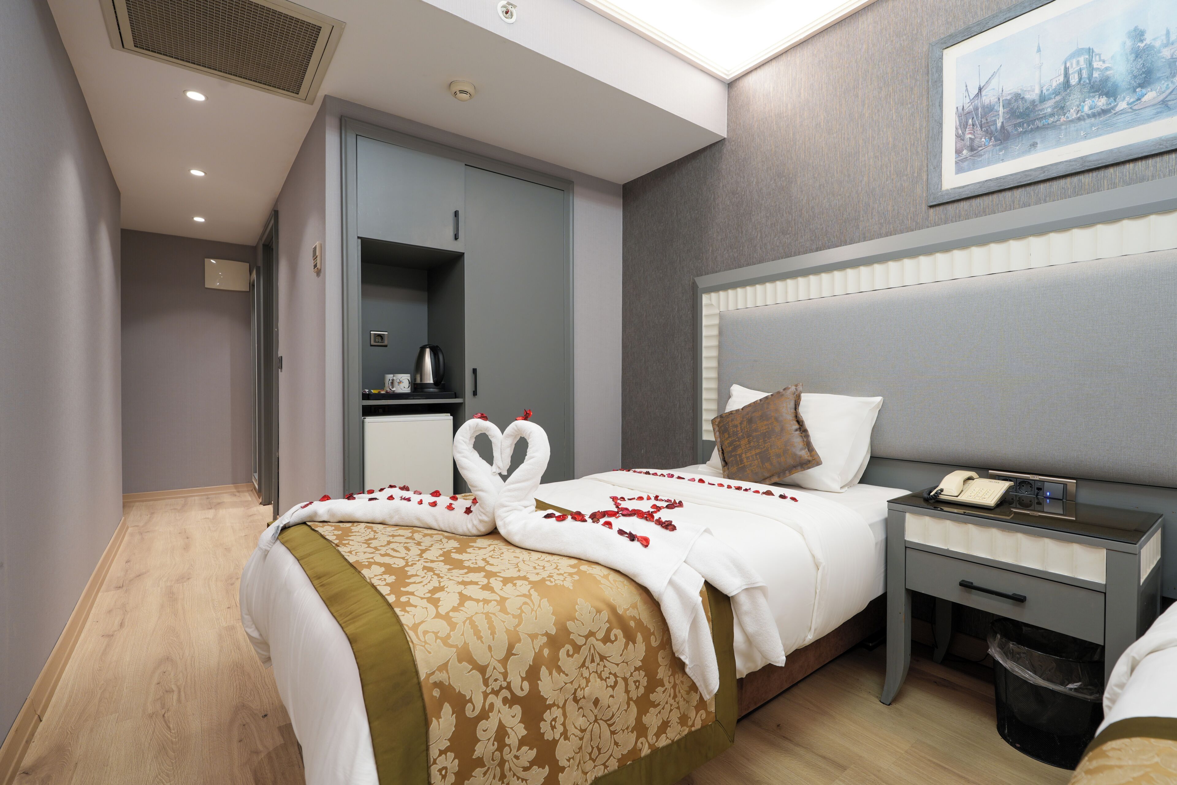 A hotel room with a bed, bedside table, and a nightstand.