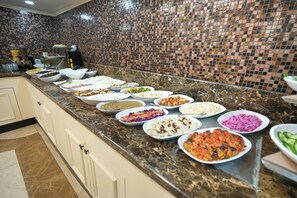A buffet line with various dishes, a tiled backsplash, and marble countertops. - Taksim Stare Hotel (Istanbul)