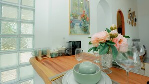 Una mesa de comedor con un bol, copas de vino y un jarrón de flores.
