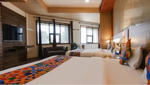 Een hotelkamer met een groot bed, een televisie, een bank en een bureau.