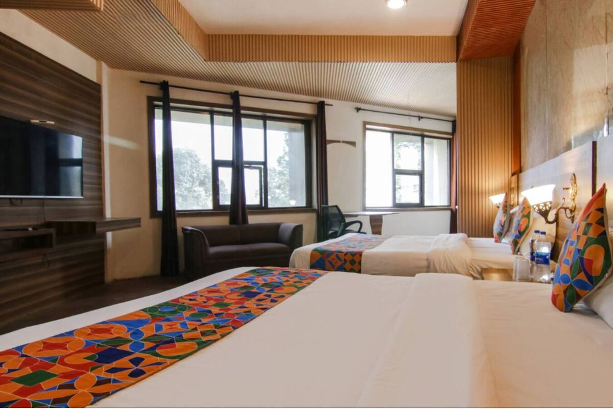 Een hotelkamer met een groot bed, een televisie, een bank en een bureau.